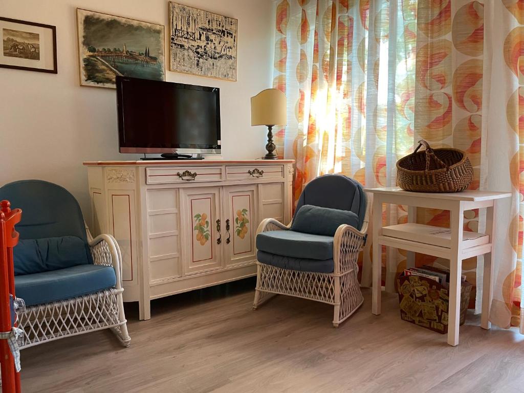 een woonkamer met 2 stoelen en een televisie bij Alhambra Sweet Home near the Sea in Duna Verde