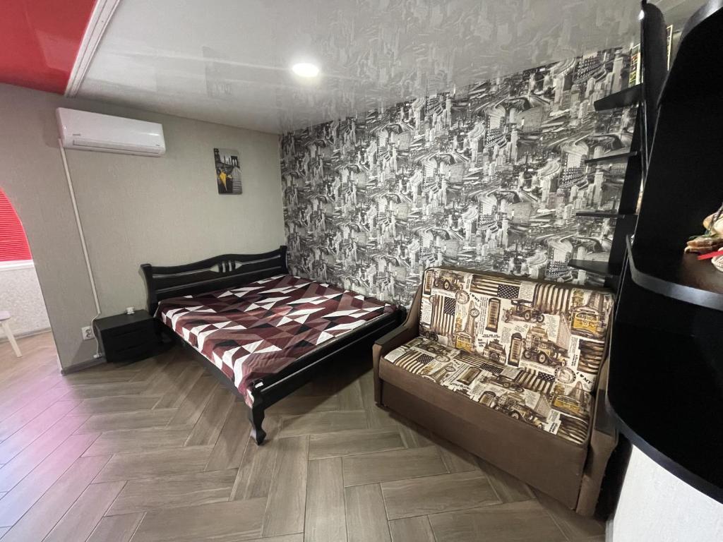 a bedroom with a bed and a wall with a mural at Studio apartment on Vatutina in Vinnytsya