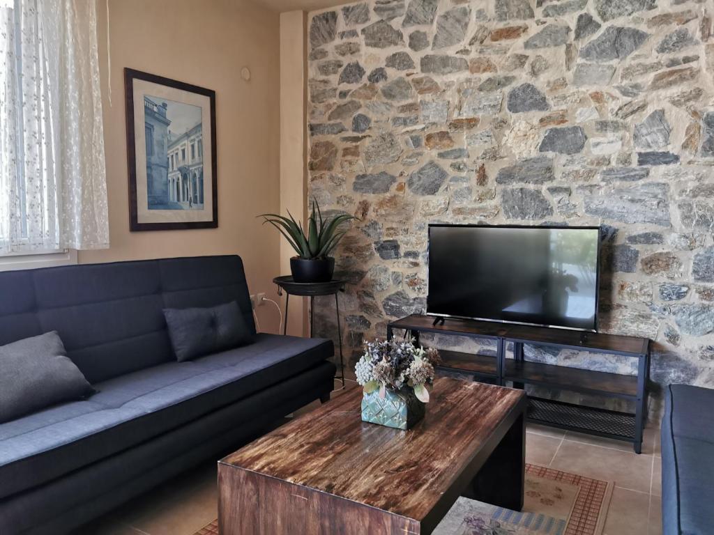 a living room with a couch and a tv at Armonia Petra House in Kavála