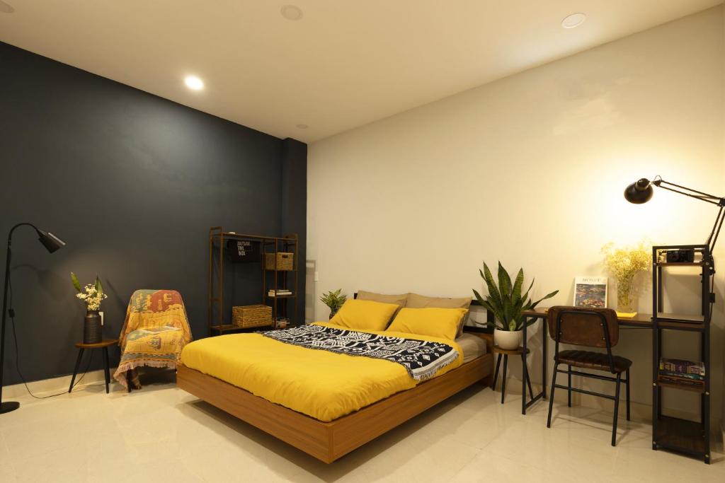 ein Schlafzimmer mit einem Bett und einer schwarzen Wand in der Unterkunft Karat Home in Ho-Chi-Minh-Stadt