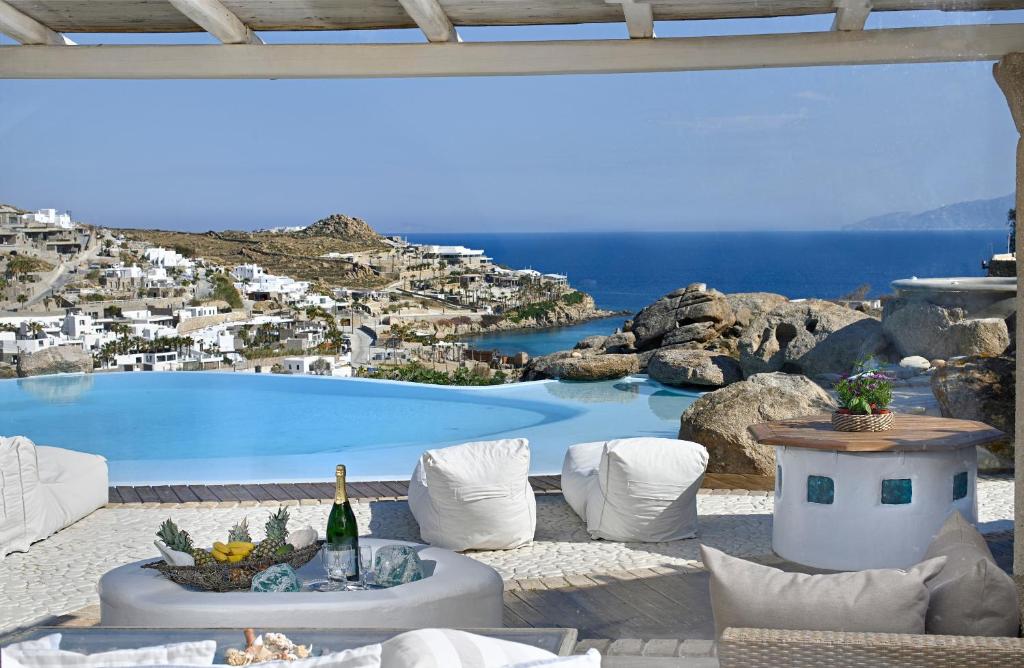 a table with a bottle of wine next to a pool at Paraga Villa1 "7min WALK TO BEACH" by Calypso Sunset Villas in Mikonos