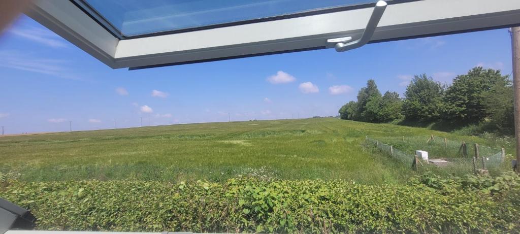 a view of a green field from a window at nid cauchois in Betteville