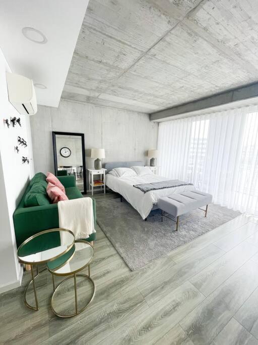 ein Schlafzimmer mit einem grünen Sofa und einem Bett in der Unterkunft * Blanc Studio Aveiro * in Aveiro
