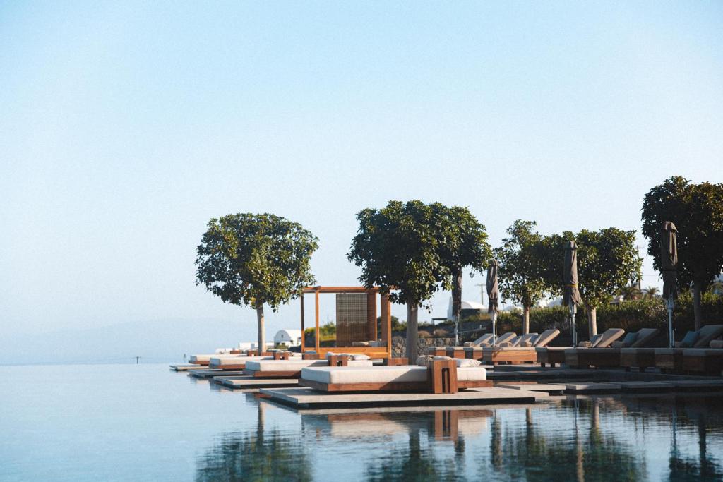 a row of lounge chairs in the water at Canaves Epitome - Small Luxury Hotels of the World in Oia