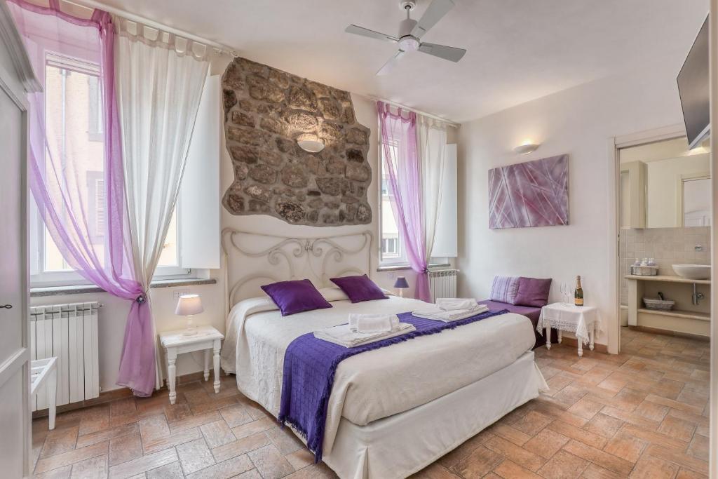 um quarto com uma cama grande e almofadas roxas em Viterbo Antica - centro storico em Viterbo
