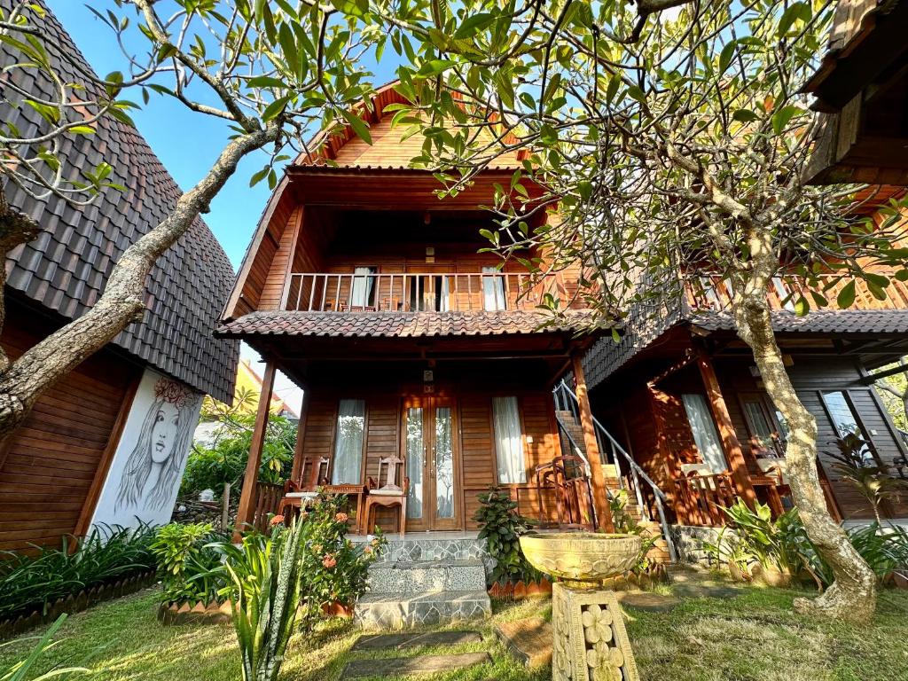 a wooden house with a porch and chairs in front of it at Boga Segara Villa And Resto in Nusa Penida