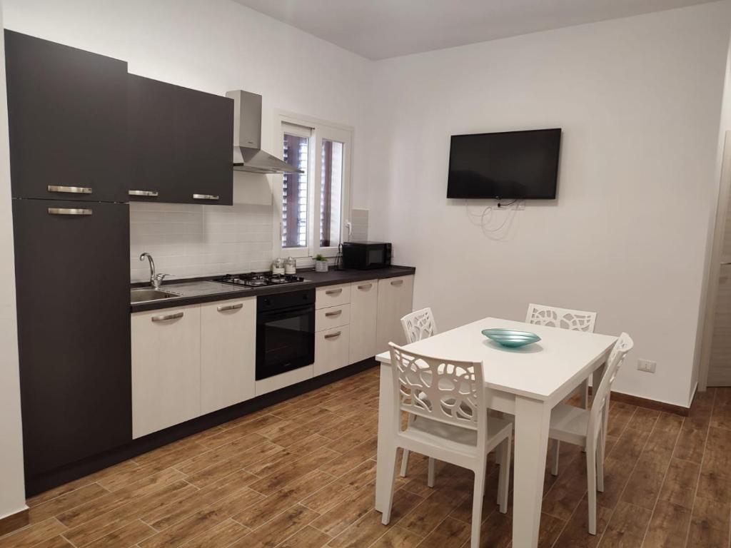 a kitchen with a white table and a black refrigerator at TRAPANI CITY SEA APARTMENT in Trapani
