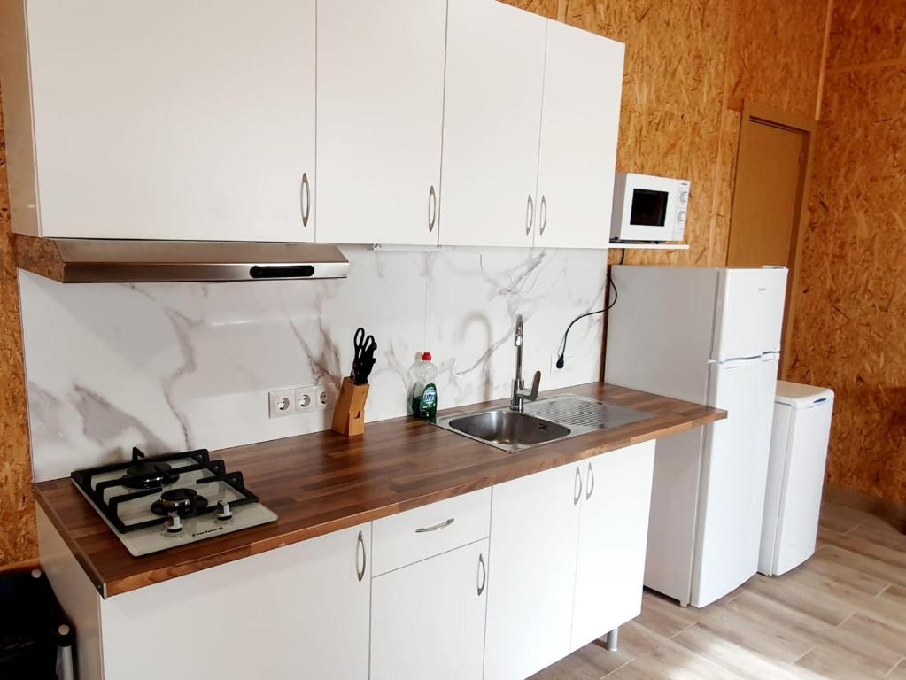 uma cozinha com armários brancos e um lavatório em Sol de Costacabana em Almeria