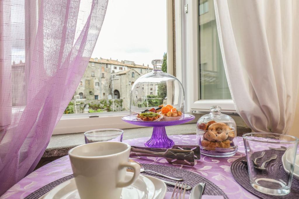 a table with a purple table cloth with a plate of food at Viterbo Antica - centro storico in Viterbo