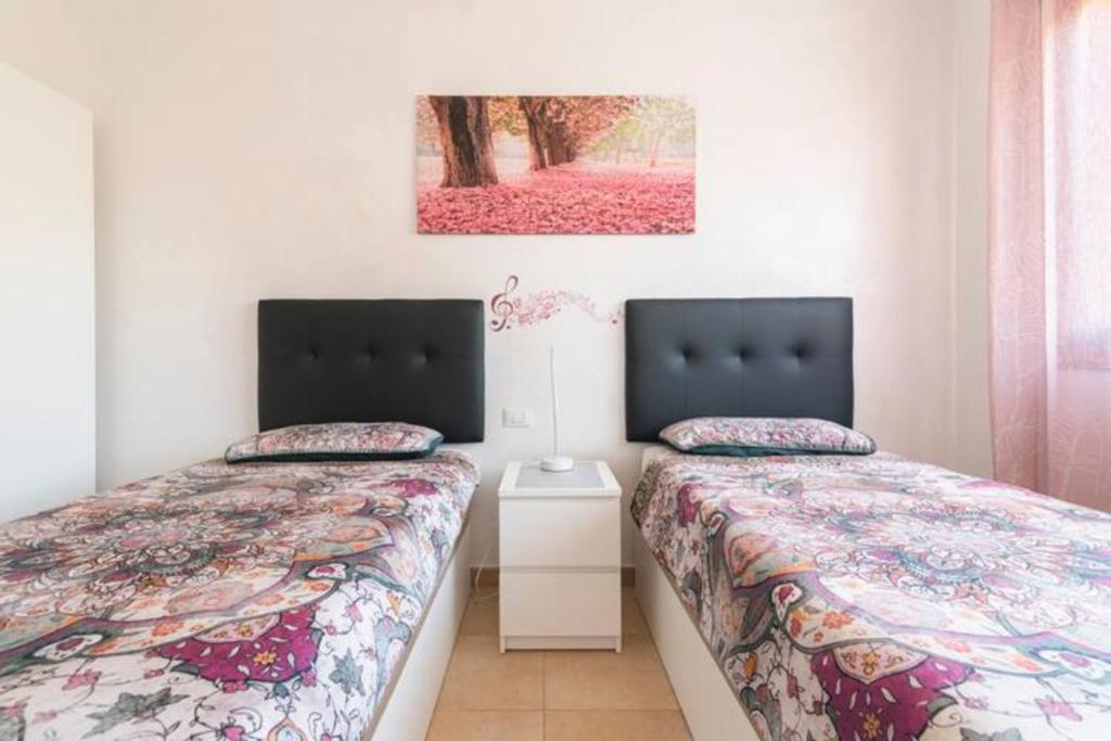 ein Schlafzimmer mit zwei Betten und einem Bild an der Wand in der Unterkunft Casa Ivonne - San Isidro in San Isidro