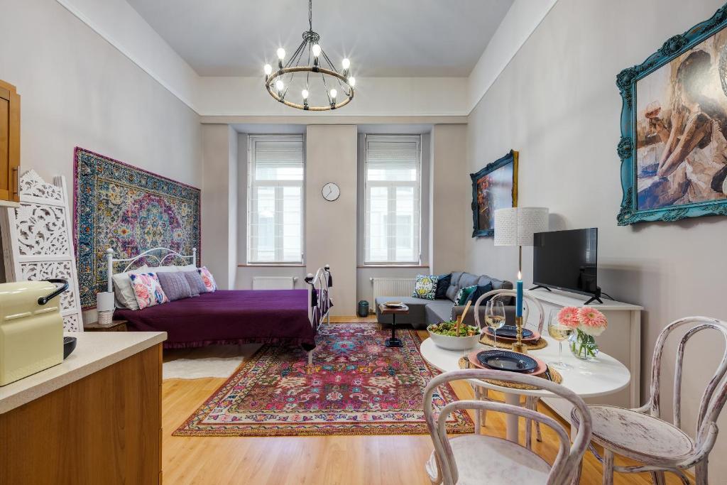 uma sala de estar com um sofá roxo e uma mesa em Bohemian studio in the city centre em Budapeste