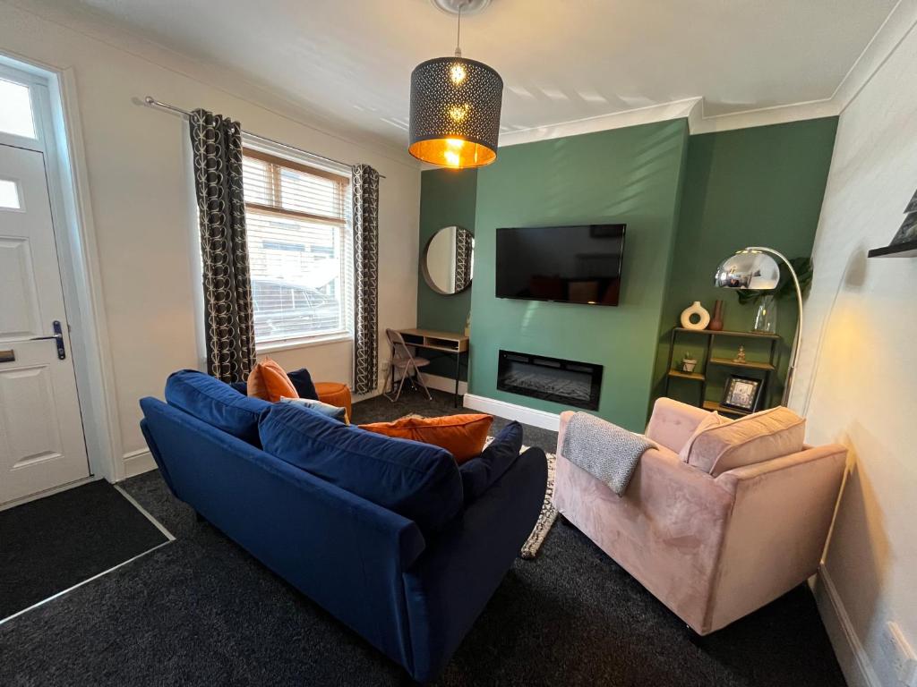 a living room with two couches and a tv at Hilton House in Barnsley