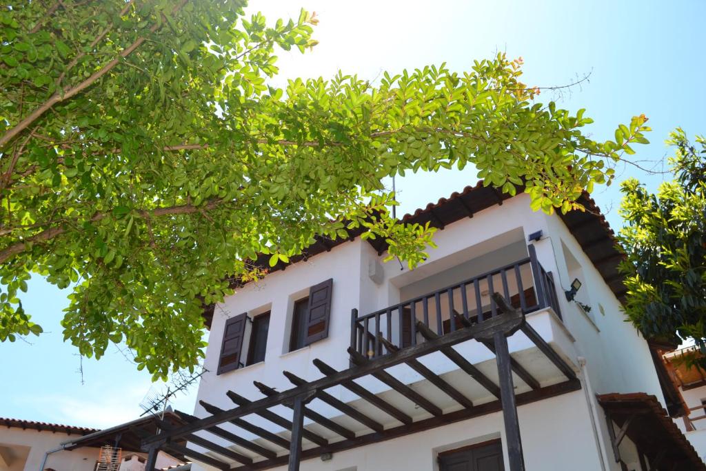 uma casa branca com uma varanda preta em Aegean View House em Agios Ioannis Pelion