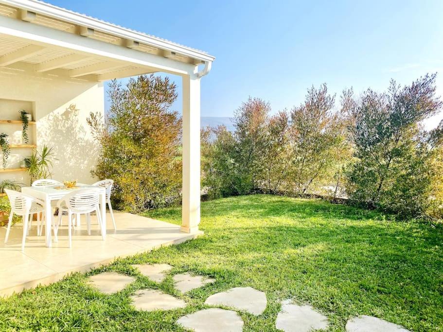 een patio met een tafel en stoelen in een tuin bij היחידה ליד הנחל עם הנוף לחרמון 33 in Sede Neẖemya