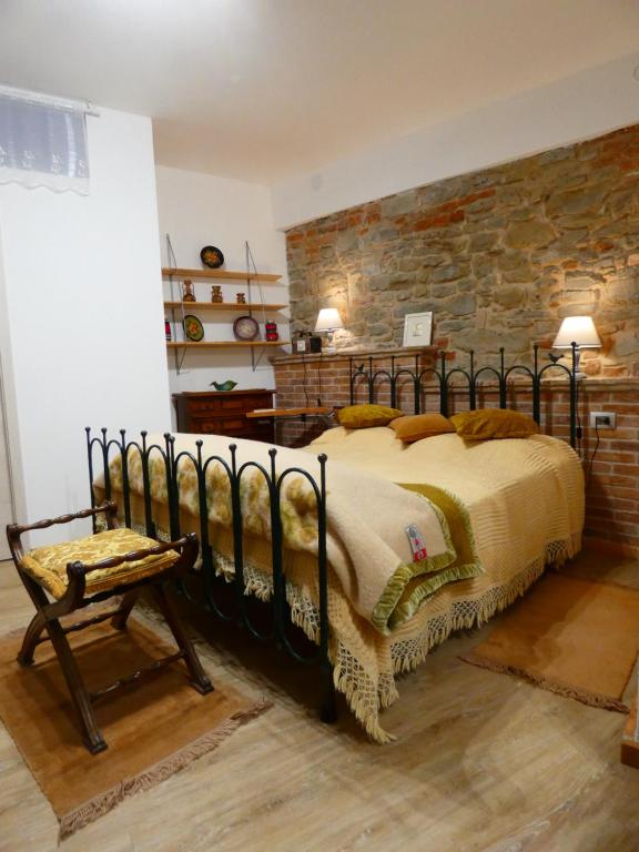 a bedroom with a bed and a stone wall at Valverde in Cengio