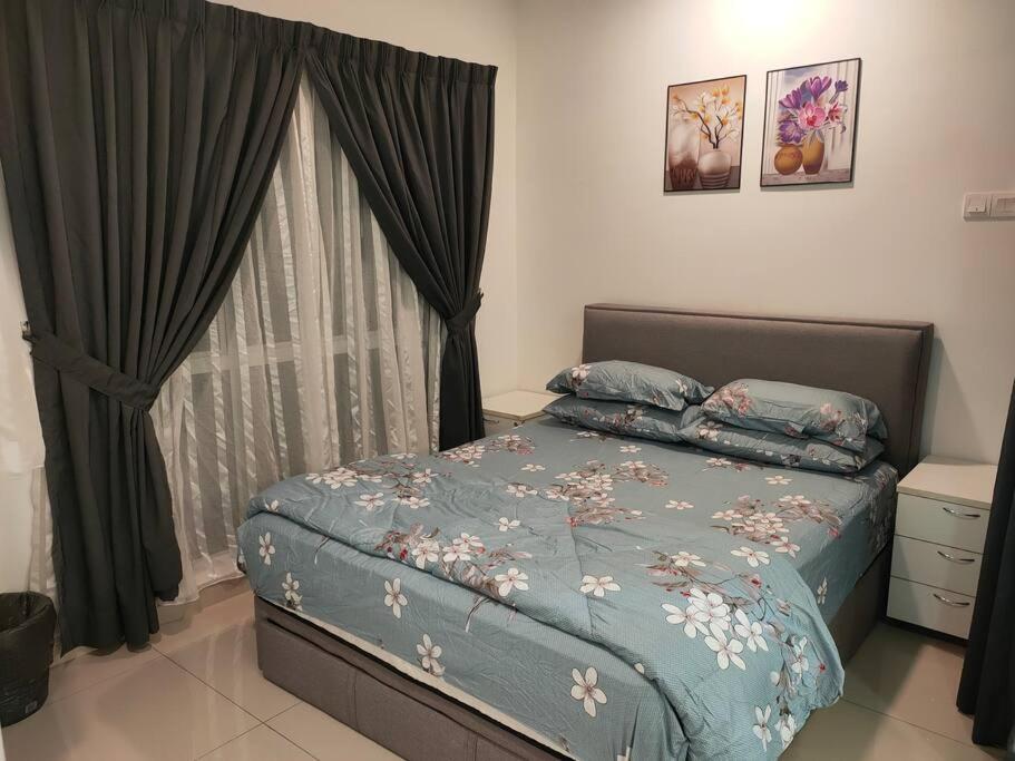 a bedroom with a bed with a blue comforter and a window at MyHome S1 At Seri Kembangan With A View in Seri Kembangan