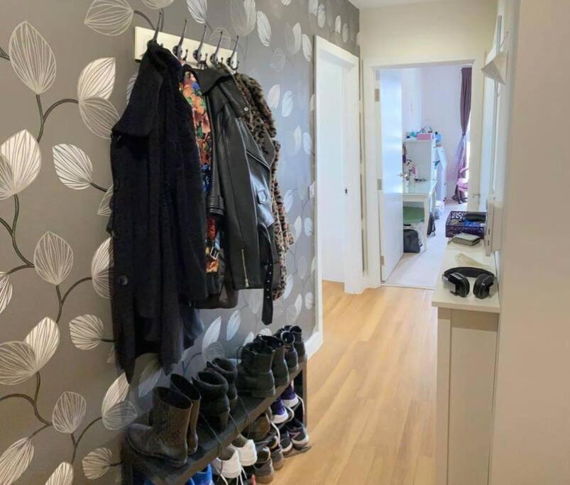 a room with a rack of shoes and a wall at 1 bedroom apartment in London
