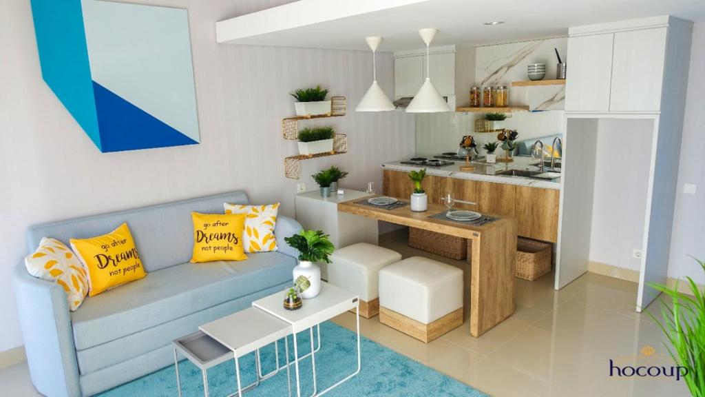 a living room with a blue couch and a kitchen at Villa Canyata in Pasuruan