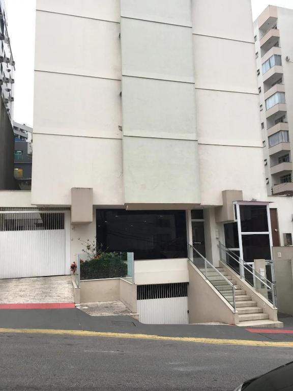 a large white building with a door and stairs at Apto climatizado -garagem in Florianópolis