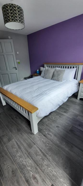 1 cama grande en un dormitorio con pared púrpura en River side, en Dingle