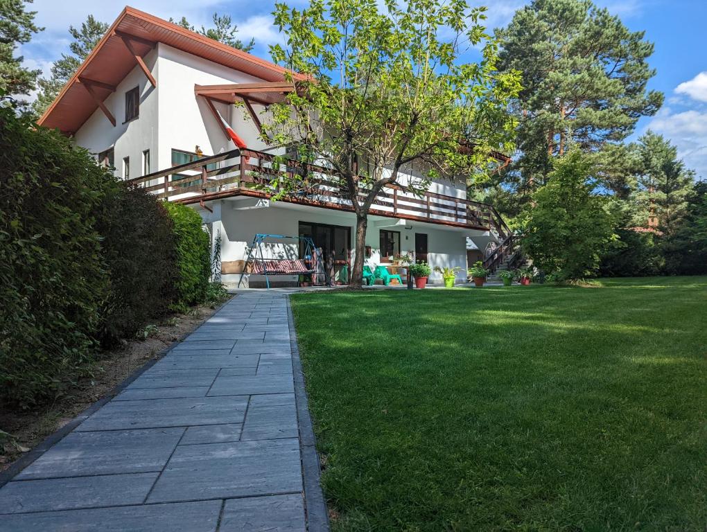 a house with a walkway in front of a yard at Dom i Domki nad Tanwią in Narol