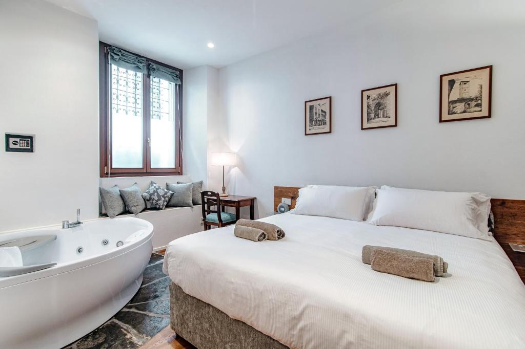 1 dormitorio con 1 cama grande y bañera en Suite Lo Storico - The House Of Travelers, en Como