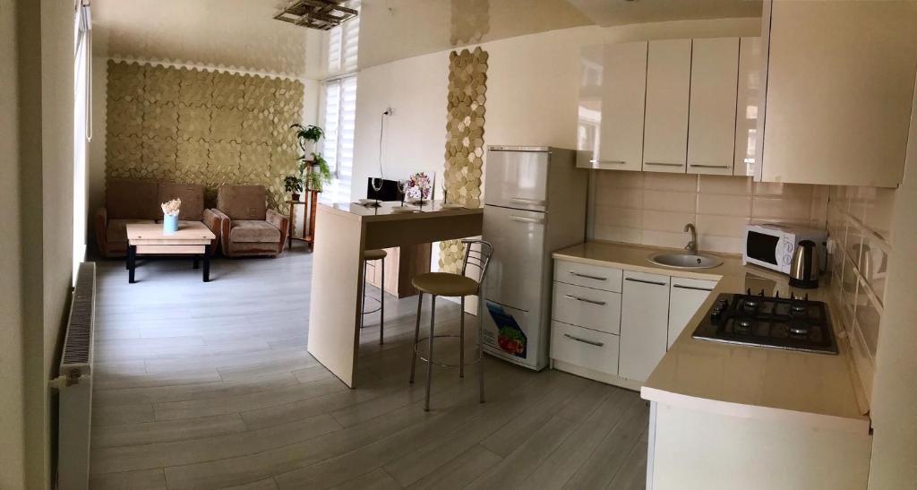 cocina con armarios blancos y sala de estar. en 2-х кімн квартира в новобудові, en Ternopilʼ