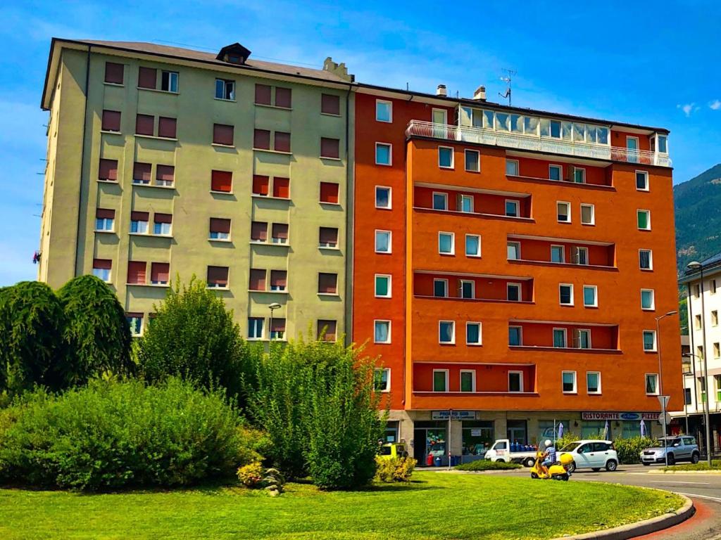 a large building with cars parked in front of it at Settimo Cielo Apartment Aosta CIR 0199 in Aosta