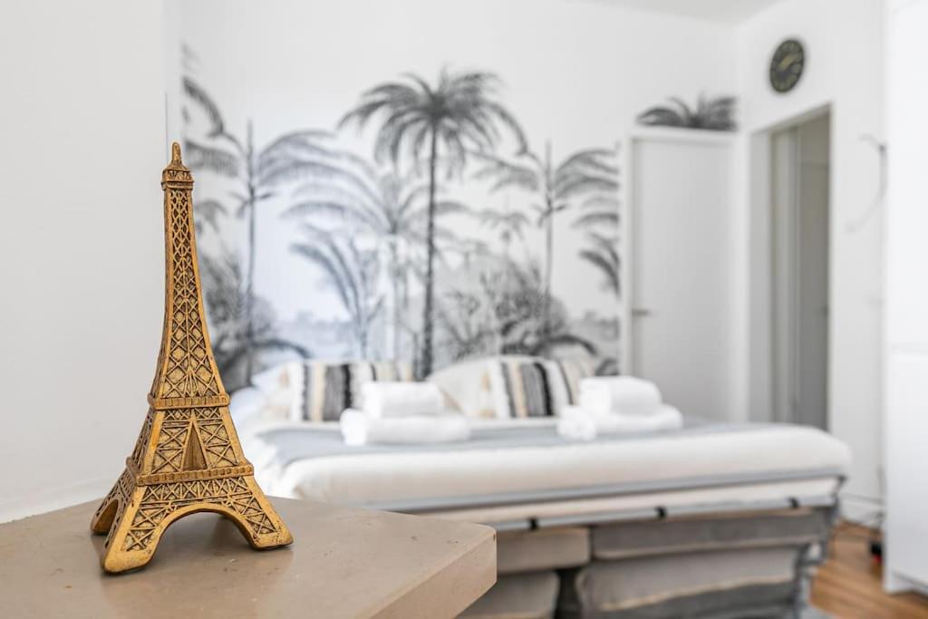a figurine of the eiffel tower on a table in a bedroom at MBA Splendide Appart - Montreuil 6 - Proches Vincennes in Montreuil