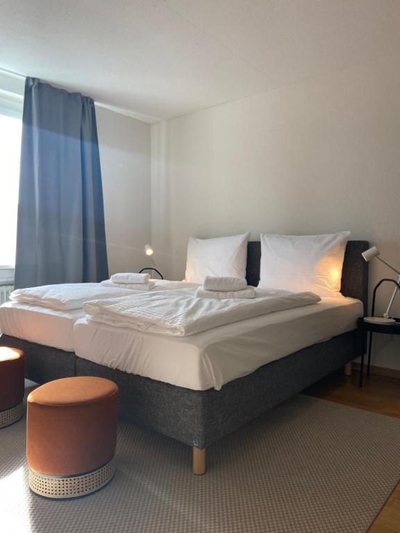 ein Schlafzimmer mit einem großen Bett mit weißer Bettwäsche und Kissen in der Unterkunft 1 BDR Apartment in Zurich West in Zürich