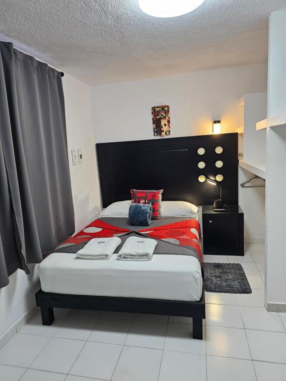 a bedroom with a bed with a red blanket at Book & Sleep Cancun in Cancún