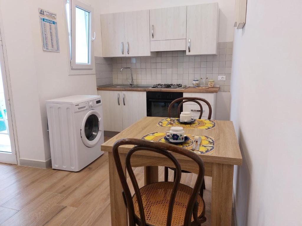 マルサラにあるCasa Antonellaのキッチン(テーブル、椅子、洗濯機、乾燥機付)