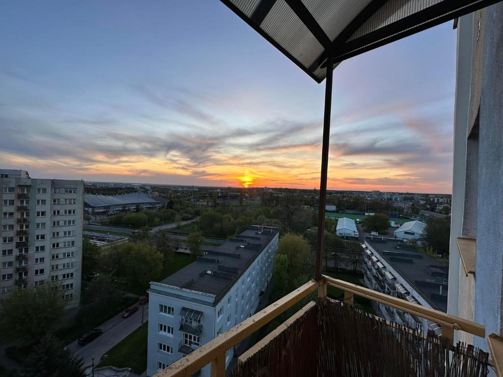 a sunset from the balcony of a building at Przytulne mieszkanie in Toruń