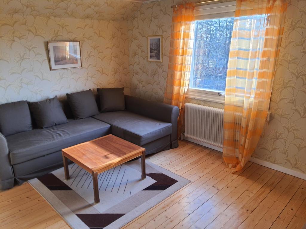 sala de estar con sofá y mesa en Liten lägenhet 2 + 2 pers en Fågelfors