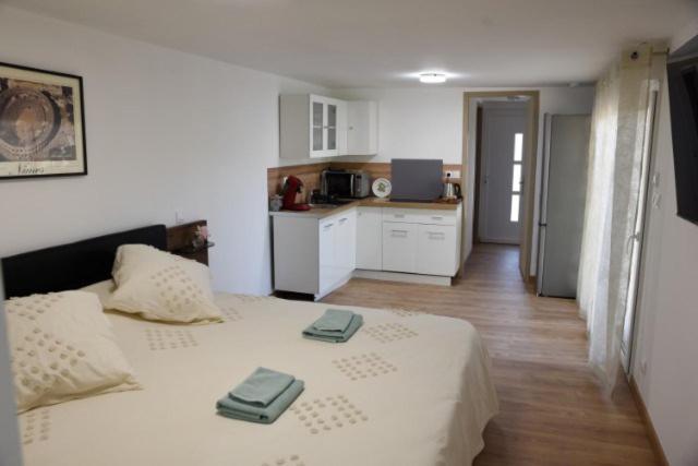 - une chambre avec un lit et 2 serviettes dans l'établissement Maison d'hotes - chambre-kitchenette-salle de bain-espace extèrieur, à Nîmes