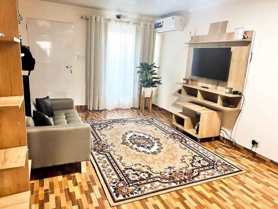 sala de estar con sofá y TV de pantalla plana en Casa entera con patio, parrilla y cochera en Lomas de Zamora