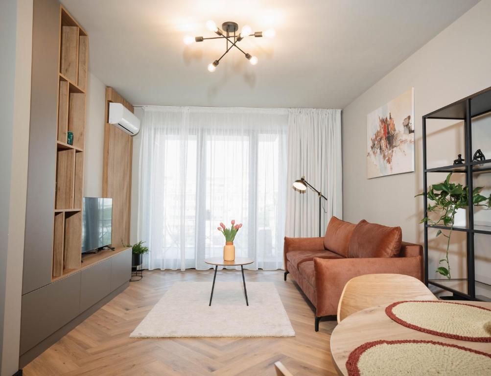 a living room with a couch and a television at Arra Apartments in Cluj-Napoca