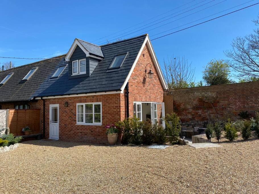 een rood bakstenen huis met een zwart dak bij The Lodge in Birchington