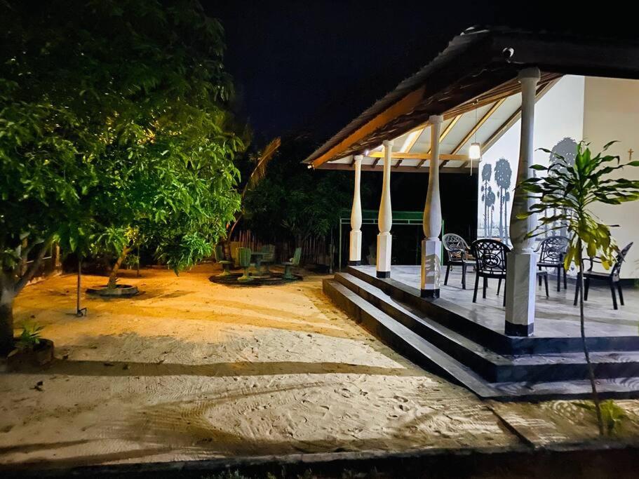 a porch of a house with chairs and trees at night at Garden Oasis with 1 Bedroom & 1 Bathroom in Batticaloa