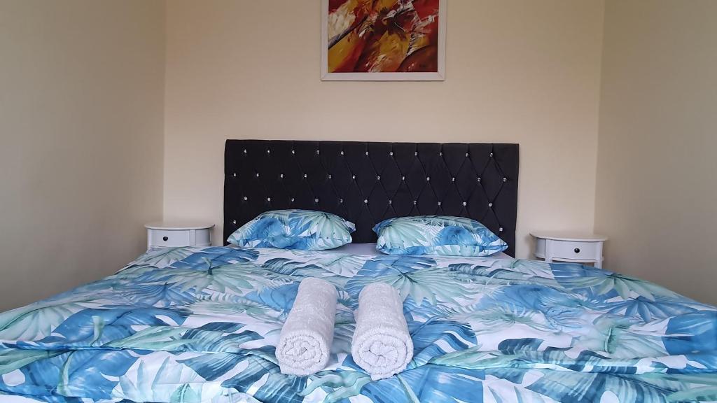 a bed with two pillows and towels on it at Apartament Estera in Oradea