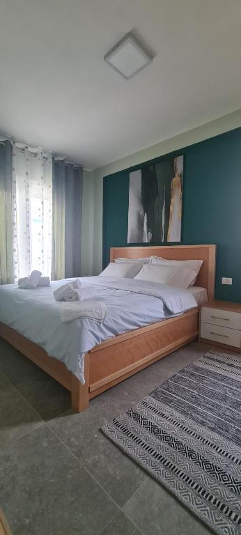 ein großes Bett in einem Schlafzimmer mit blauer Wand in der Unterkunft Ermar Apartment in Golem