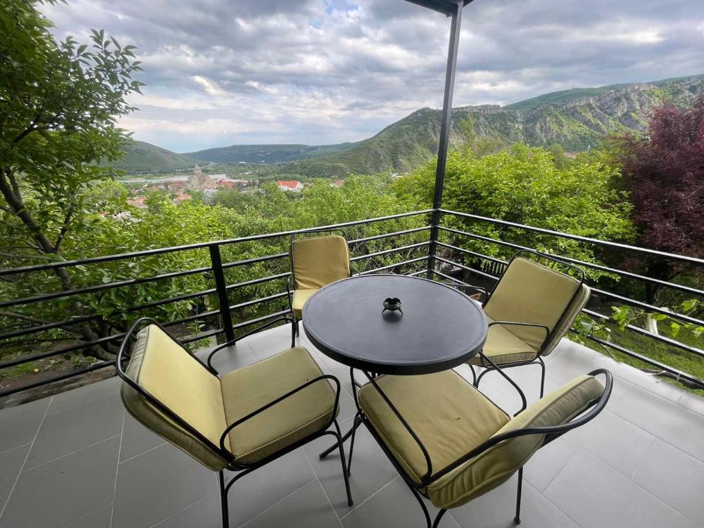 a table and chairs on a balcony with a view at panorama in Mtskheta