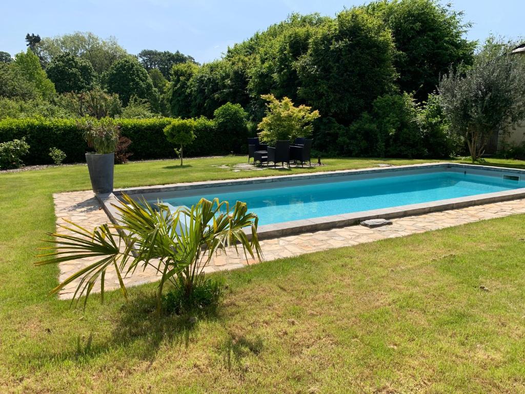 a swimming pool in a yard next to a field at Le Petit Vigneau in Ménil