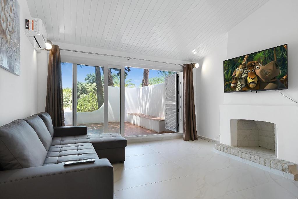 a living room with a couch and a fireplace at Pool side Villa Zara in Albufeira