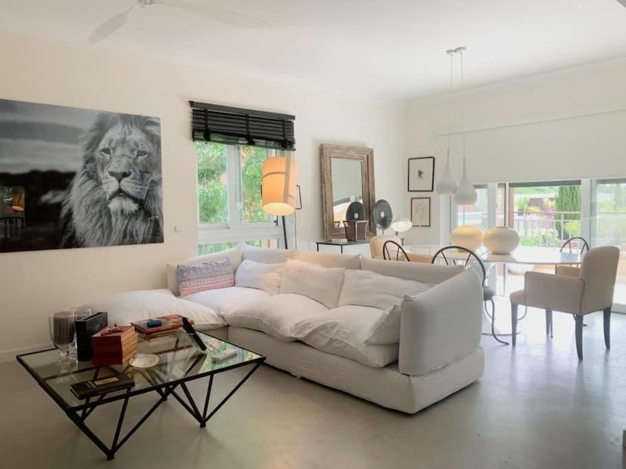 a living room with a white couch and a lion painting at White shell vilamoura in Maritenda