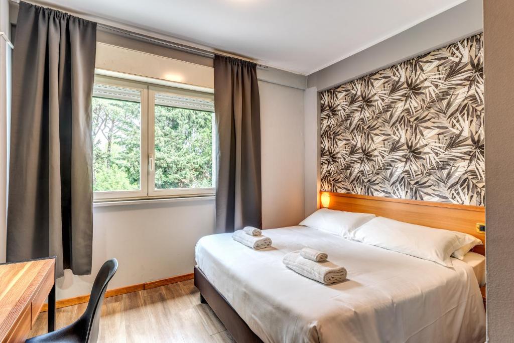 1 Schlafzimmer mit einem Bett, einem Schreibtisch und 2 Fenstern in der Unterkunft Scheppers Hotel in Rom