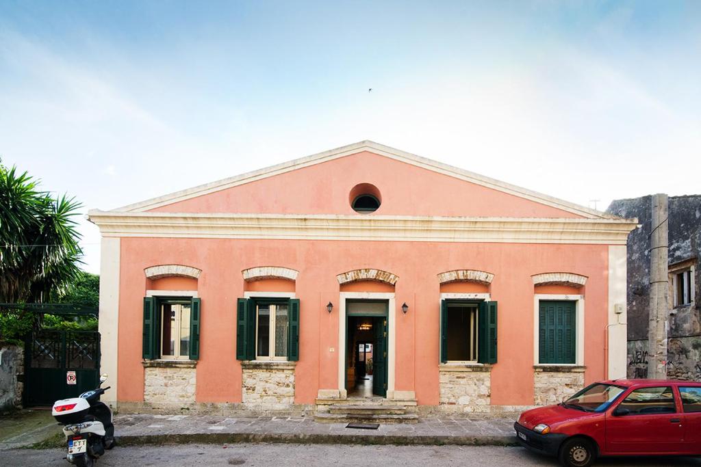 a red car parked in front of a building at Moraitis Mansion in Corfu