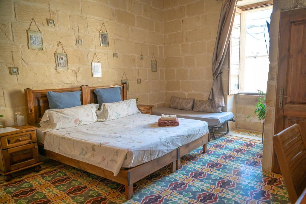 a bedroom with a bed and a couch in it at Laremi Gozo B&B in Nadur