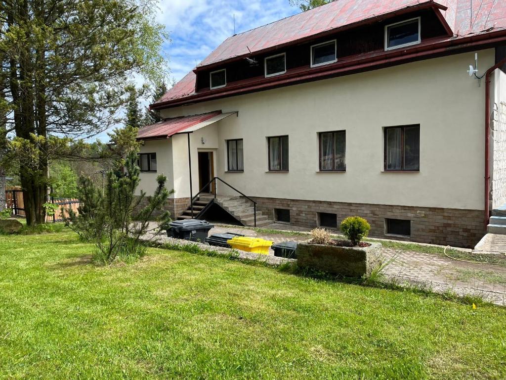 Casa blanca con techo rojo y patio en Chata JedlOvka en Jiřetín pod Jedlovou