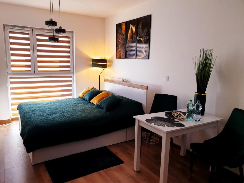 um quarto com uma cama e uma mesa em Fachpol Apartments Sienkiewicza 22D em Zamość